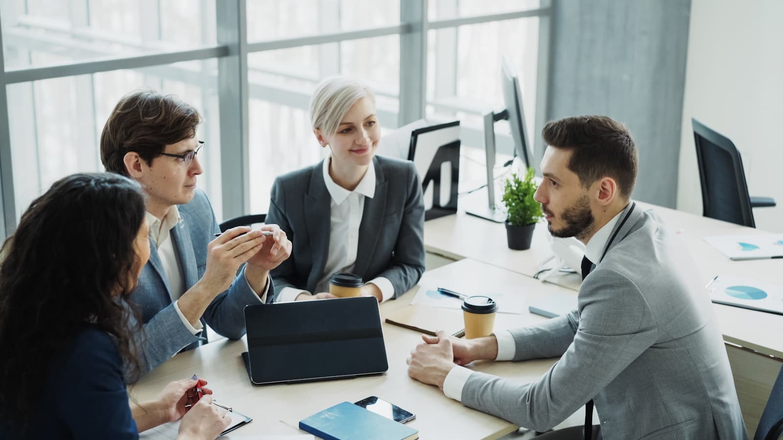 Team i lyst kontormiljo som diskuterer prosjekt og prioriteringer